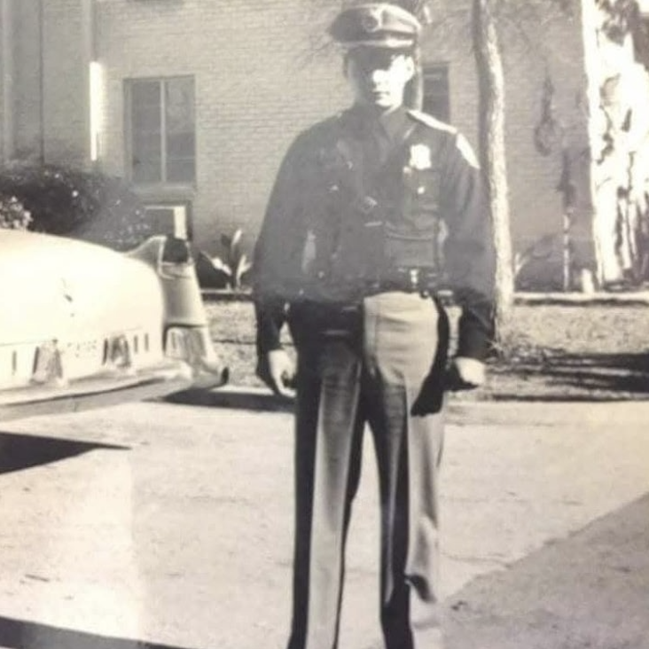 Man standing in front of patrol car
